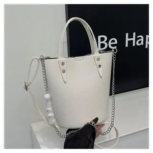 Detail of white lychee pattern bucket bag with decorative beaded chain and silver rivets