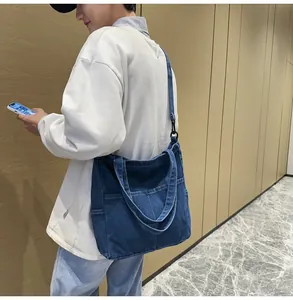 Dettaglio borsa tote in denim blu scuro con tracolla regolabile e tasche frontali