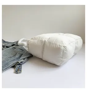 Détail du sac fourre-tout matelassé blanc avec texture en nylon et poignées rembourrées