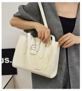 Detail of cream white tote bag with faux crocodile texture and silver metal buckle