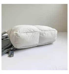 Détail du sac cabas matelassé blanc avec texture rembourrée et finition brillante