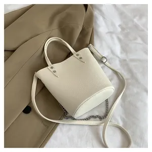 Close-up of cream lychee texture bucket bag with silver chain and dual straps