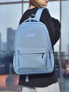 Sac à dos en nylon bleu clair imperméable pour l'école et le travail porté par un modèle
