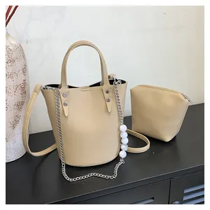 Detail view of khaki bucket bag set with pearl chain decoration and pebbled faux leather texture