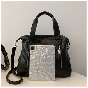 Détail montrant la grande capacité intérieure du sac cabas en cuir noir avec une tablette