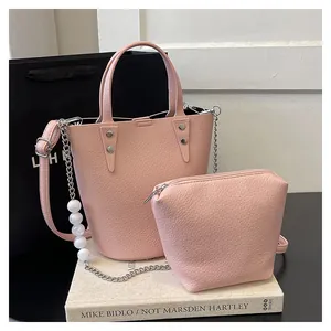 Detail of pink lychee leather bucket bag set with pearl chain and silver hardware