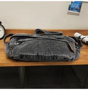 Macro-opname van grijze gewassen denim crossbodytas met vintage textuur en zwarte rits