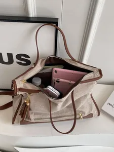 Canvas tote bag with brown leather trim showing large capacity for tablets and bottles