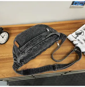Detail van retro gewassen denim crossbodytas met leren patch op een houten oppervlak