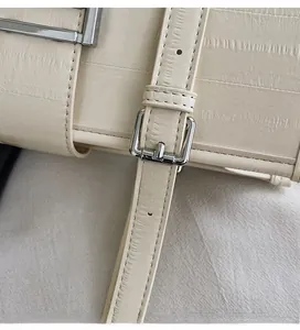 Detail of cream leather texture and silver buckle on the stylish French tote bag strap