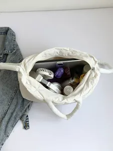 Sac fourre-tout matelassé blanc à grande capacité montrant l'intérieur spacieux et les objets