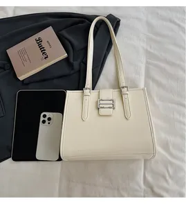 Detailed top view of off-white textured leather tote bag with tablet and daily essentials