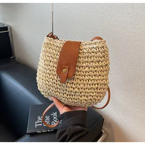 Détail de la texture paille tissée et rabat en cuir marron avec boucle en métal