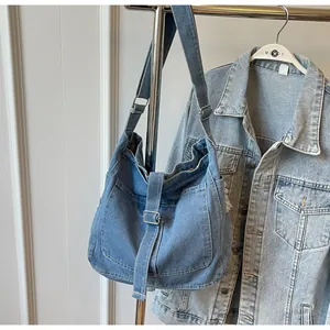Detail of adjustable strap and silver buckle on a vintage blue denim crossbody bag