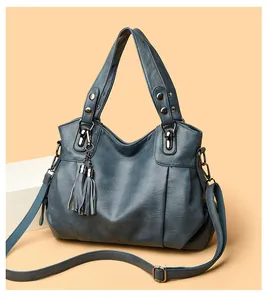 Detail of vintage blue tote bag showing soft PU leather texture and detachable tassel
