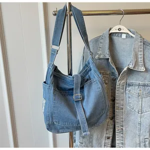 Detail of blue denim tote bag with adjustable strap and vintage distressed texture