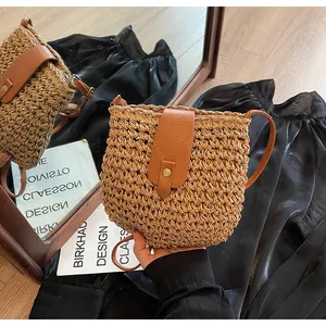 Vue détaillée du sac en paille tressée avec rabat en cuir marron et boucle dorée ronde