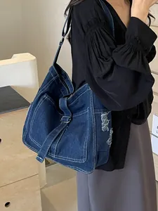 Large denim tote bag with white contrast stitching and adjustable shoulder strap for women