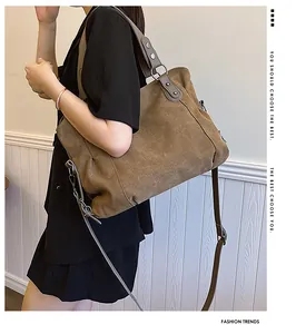 Détail d'un grand sac fourre-tout en toile marron avec lanières en cuir sur modèle