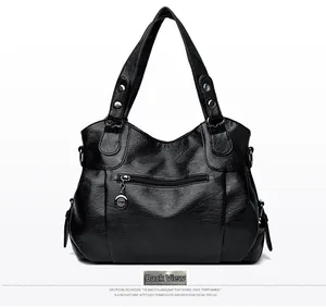 Detailed back view of a black tote bag showing a horizontal zipper pocket and metal pendant