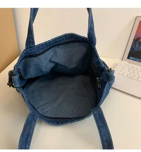 Vista dettagliata della borsa tote in denim con ampio spazio interno e chiusura con cerniera lampo