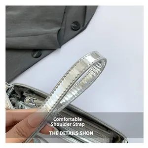 Detail showing the comfortable silver chain strap and metallic finish of the bag