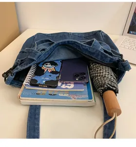 Vista interna della borsa tote in denim che mostra l'ampia capacità per telefono e rivista
