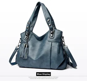 Detailed blue pebbled leather tote featuring side pleats and a decorative fringe charm
