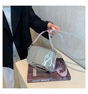 Detail view of silver liquid metal texture shoulder bag with elegant chain strap