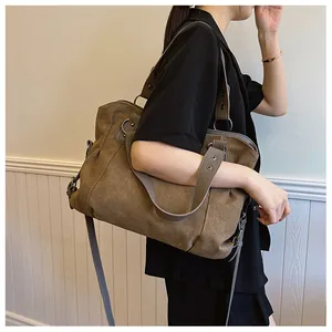 Détail d'un grand sac cabas en toile marron avec bandoulière dans un décor minimaliste