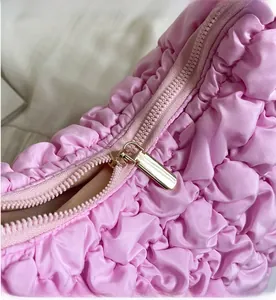 Close-up of smooth metal zipper and pink bubbly textured fabric on the puffy bag