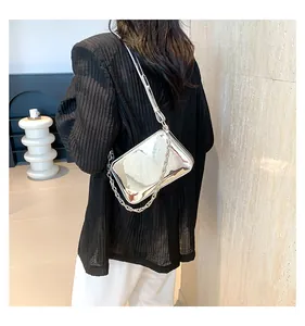 Detail view of silver mirror finish handbag with thick metal chain and sleek leather strap