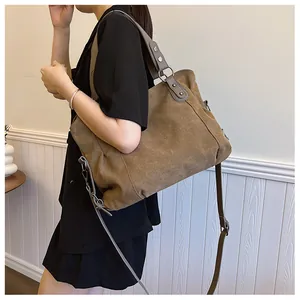 Détail d'un sac cabas en toile vintage avec bretelles en simili cuir marron et rivets