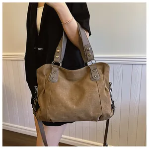 Détail du grand sac cabas marron foncé avec poignée à rivets et bandoulière réglable
