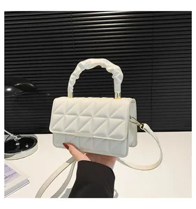 Détail du sac beige matelassé avec poignée froncée et accents métalliques dorés