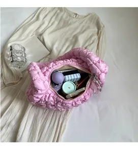 Detail of pink puffy shoulder bag showing spacious interior with phone and umbrella