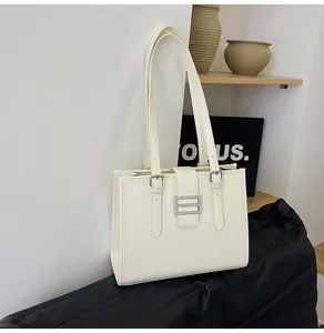 Detailed macro shot of creamy crocodile pattern texture and silver hardware on tote bag