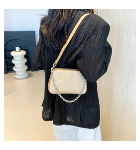 Close-up of beige woven crossbody bag with silver chain strap and leather details