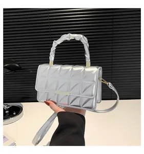 Détail du sac à main matelassé argenté avec finition métallique et poignée nuage froncée