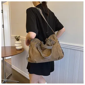 Détail du sac cabas en toile taupe avec bandoulière grise et rivets métalliques argentés