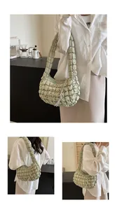 Close-up detail of light green quilted bubble bag featuring soft fabric and silver zipper