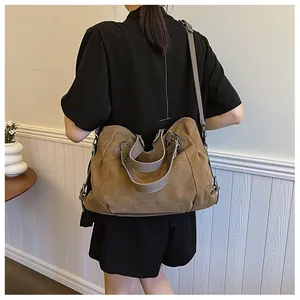 Vue détaillée du sac cabas en toile kaki avec des bandoulières en cuir marron porté