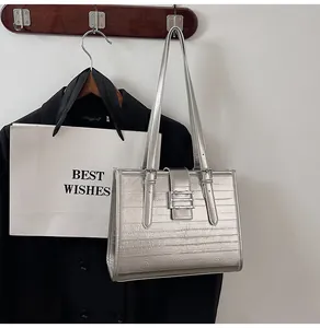 Detail of metallic silver tote bag with textured pleats and long shoulder straps