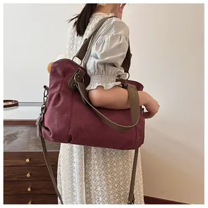 Détail du sac cabas en toile bordeaux avec anses en cuir kaki et plis naturels
