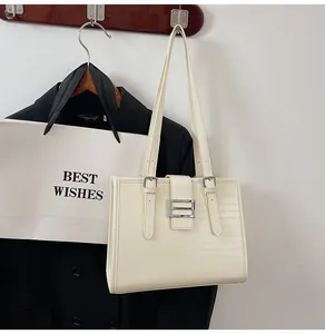 Detail of cream tote bag featuring horizontal texture and silver metal buckle
