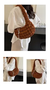 Detail of a brown quilted cloud bag featuring a decorative silver rhinestone knot chain