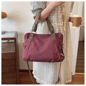 Vue détaillée du grand sac cabas en toile bordeaux avec poignées et bandoulière marron