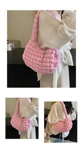 Detailed close-up of pink quilted cloud bag featuring puff texture and silver chain charm