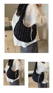 Close-up of black quilted bubble hobo bag featuring a sparkling rhinestone knot drawstring