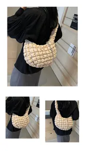 Detail shot of beige cloud bag featuring bubble texture and silver tassel accents